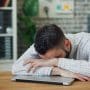 Salarié épuisé, la tête posée sur son bureau