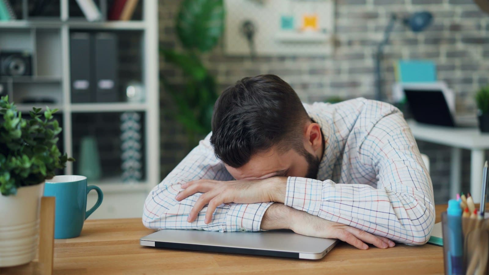 Salarié épuisé, la tête posée sur son bureau